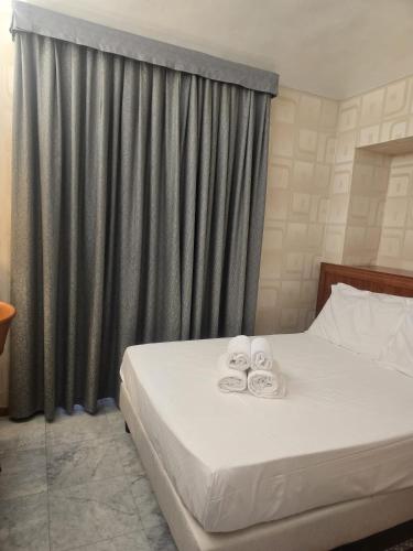 a bedroom with a bed with two towels on it at Hotel Chelsea in Turin