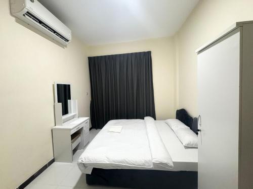 una piccola camera da letto con un letto e una televisione di FZ Star Residence a Dubai
