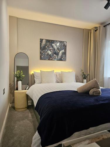 a bedroom with a large bed with a blue blanket at Long Short Stays Driveway 2-Bed Hull in Hull