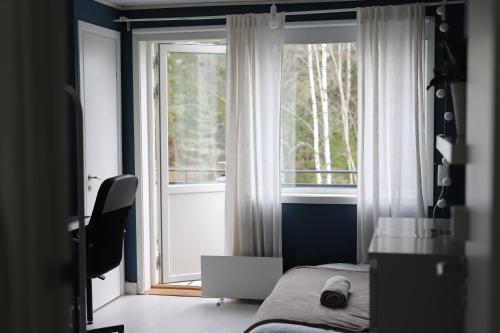 a bedroom with a bed and a large window at Highland Hus in Hallstahammar