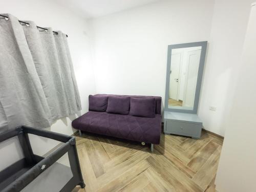 a purple couch in a room with a mirror at נוי גלילי in Mitspe Netofa