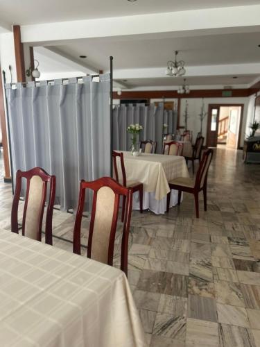 a dining room with two tables and chairs with white table cloth at Hotel Restauracja Kaukaska Jadwiga Choroszy in Wolsztyn