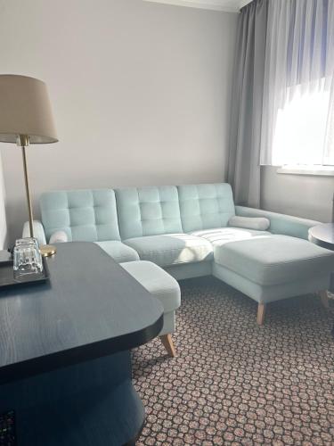a living room with a couch and a table at Hotel Restauracja Kaukaska Jadwiga Choroszy in Wolsztyn