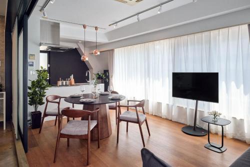 a dining room with a table and chairs and a tv at R STAY Shiba in Tokyo