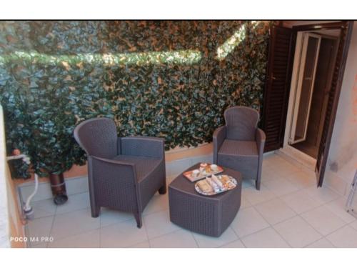 a group of chairs and a table in front of a wall at Grotthouse in Andria