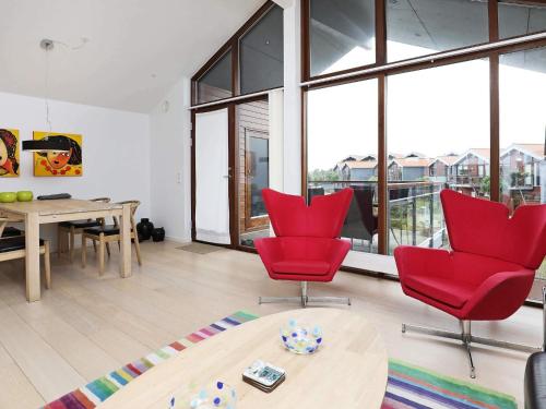 a living room with red chairs and a table at 4 person holiday home in Bogense-By Traum in Bogense