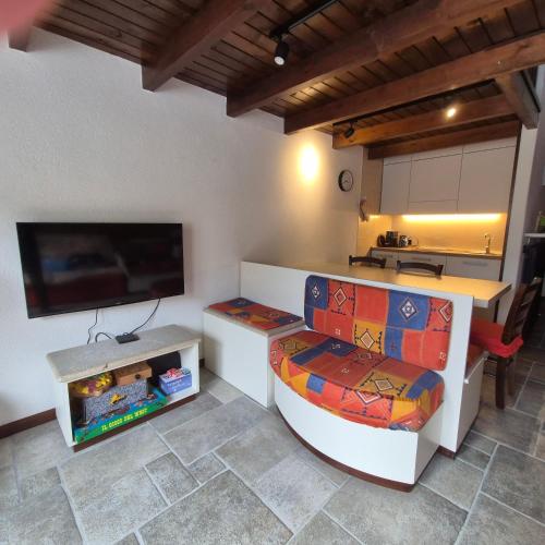 Habitación con cocina con barra y TV. en Accogliente Bilocale vicino Monte Pora - Presolana, en Malga Alta