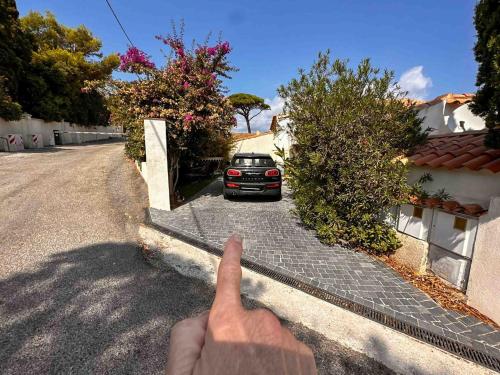 a person pointing at a car parked on a street at Luxueux haut de villa 4 per à 30m de la plage in Sainte-Maxime