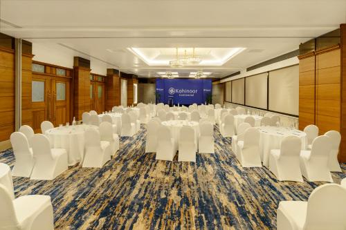a conference room with white tables and white chairs at Hotel Kohinoor Continental, Airport - Newly Renovated in Mumbai