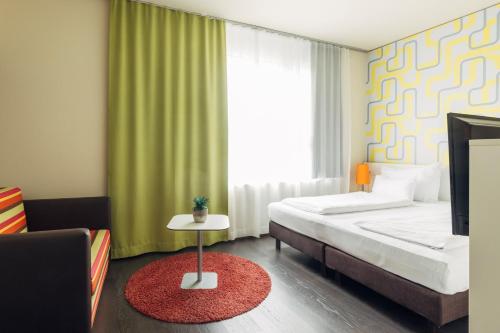 a bedroom with a bed and a window and a rug at harry's home Dornbirn hotel & apartments in Dornbirn