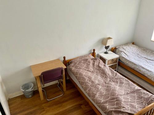 a bedroom with two beds and a table and a chair at Blue Beach in Hove