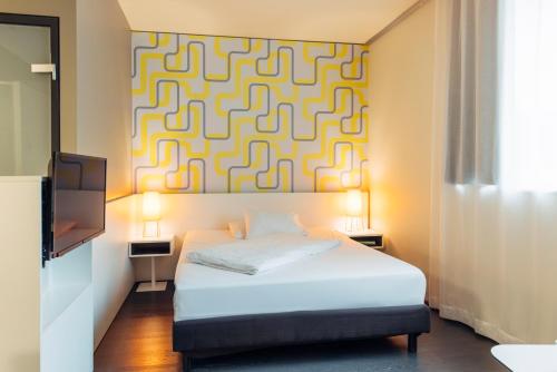 a bedroom with a bed and a painting on the wall at harry's home Dornbirn hotel & apartments in Dornbirn