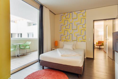 a bedroom with a bed and a living room at harry's home Dornbirn hotel & apartments in Dornbirn