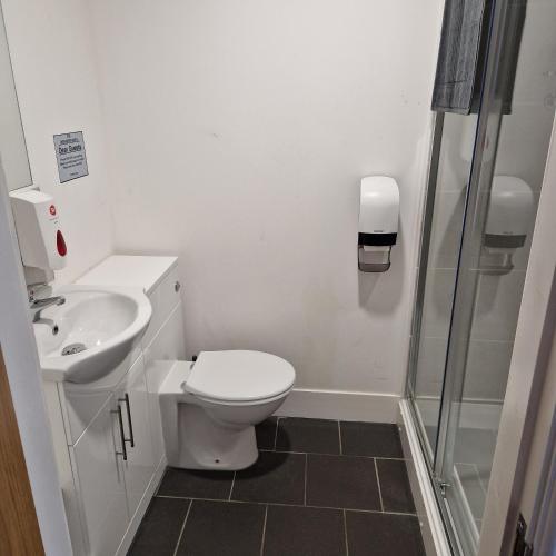 a bathroom with a toilet and a sink and a shower at The Dorchester Hotel & serviced apartments in Hull