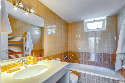 ein Badezimmer mit Waschbecken, Badewanne und Spiegel in der Unterkunft Villa Alexis House by Villa Plus in Kalo Chorio