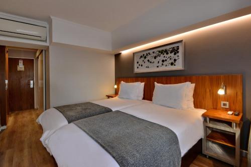 a bedroom with a large white bed in a room at City Lodge Hotel Bloemfontein in Bloemfontein