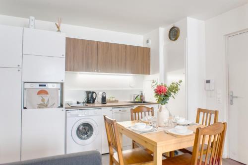 Una cocina con una mesa de madera y un comedor. en Appartement agréable Parking inclus, en Aubervilliers