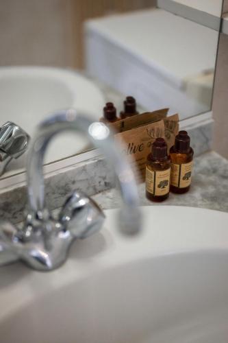 a bathroom sink with three bottles of medicine on it at LE STELLA - Central - Terrasse - Parking privé - Wifi in Roquebrune-Cap-Martin