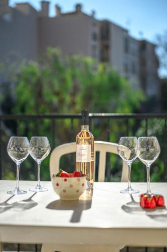 a bottle of wine sitting on a table with wine glasses at LE STELLA - Central - Terrasse - Parking privé - Wifi in Roquebrune-Cap-Martin