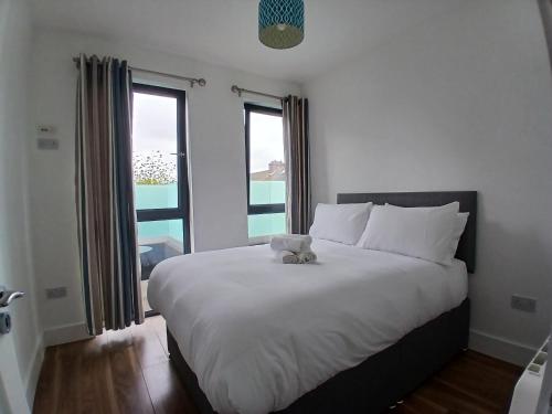 a teddy bear sitting on a bed in a bedroom at Newly Refurbed 2BD Wraparound Balcony 5km to City in Dublin