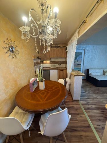 comedor con mesa de madera y lámpara de araña en Dunavski raj, en Donji Milanovac