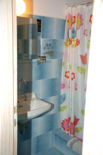 a bathroom with a sink and a shower curtain at Ψιλή Άμμος in Tolo
