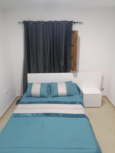 1 dormitorio con cama azul y cortina negra en Sossego & Conforto, en Espargos