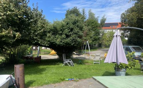 a yard with a white umbrella in the grass at Ferienwohnung Altes Rathaus Bergalingen in Rickenbach