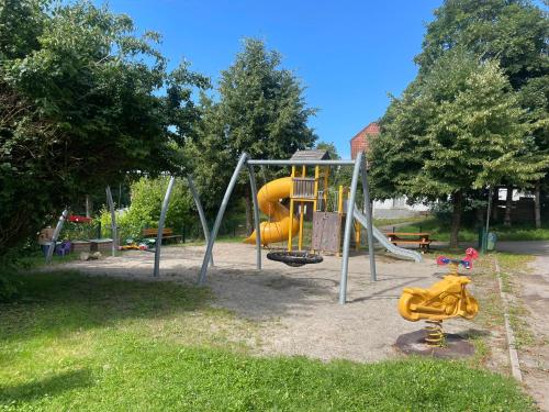 a playground with a yellow slide in a park at Ferienwohnung Altes Rathaus Bergalingen in Rickenbach