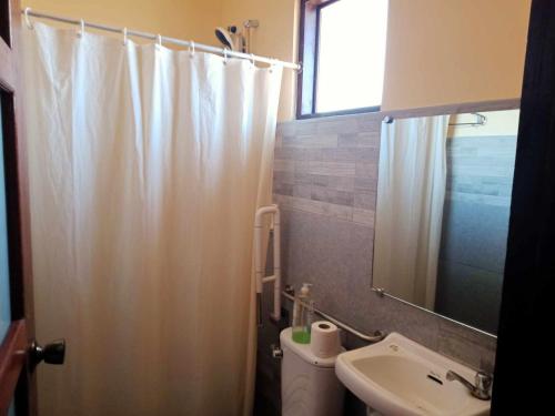 a bathroom with a shower curtain and a sink at Marianne's Guest House in New Agutaya