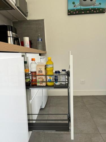 a shelf in a kitchen with food on it at Appartement T2 calme à Illkirch avec parking privé in Illkirch-Graffenstaden