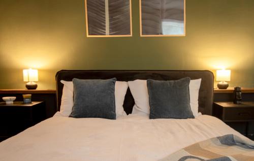 a bedroom with a bed with pillows and two lamps at Olive Central in Craiova