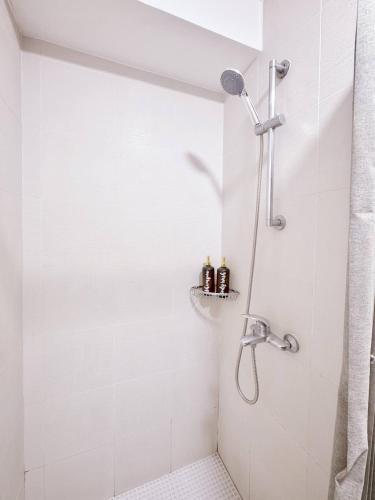 a bathroom with a shower with white tiles at Stunning 42nd Floor Apt with Netflix in Manila
