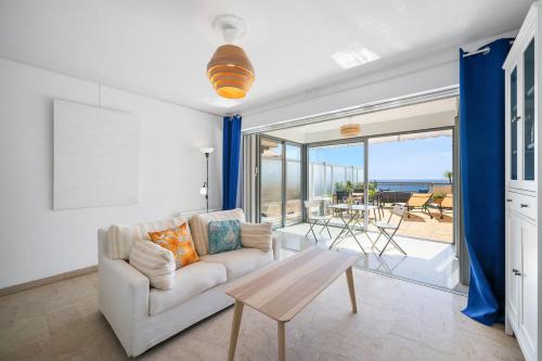 a living room with a couch and a table at L'HORIZON - Vue MER - Terrasse - Parking Privé - Calme in Menton