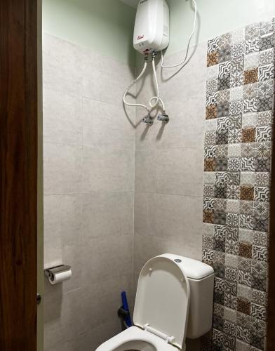 a bathroom with a white toilet in a room at Alma by MyCasa Elegant 2BHK Stay in TTK Road in Chennai