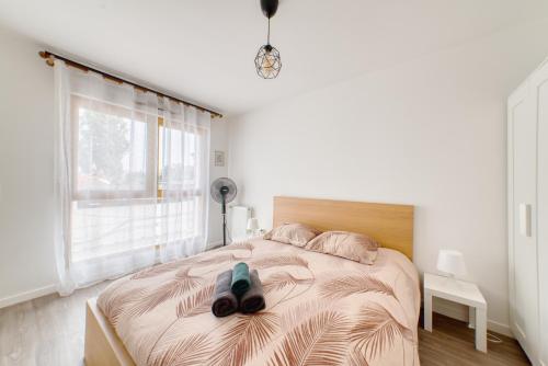 Un dormitorio con una cama con un par de zapatos encima. en Appartement agréable Parking inclus, en Aubervilliers