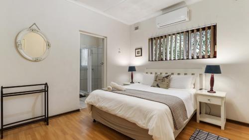 a bedroom with a large bed and a mirror at Emerald Cove in Shelly Beach