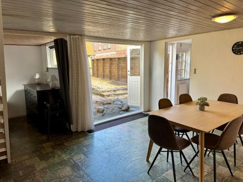 a dining room with a table and chairs and a window at Kaj Munks Gade 19 - 3 værelses - 98m2 in Maribo