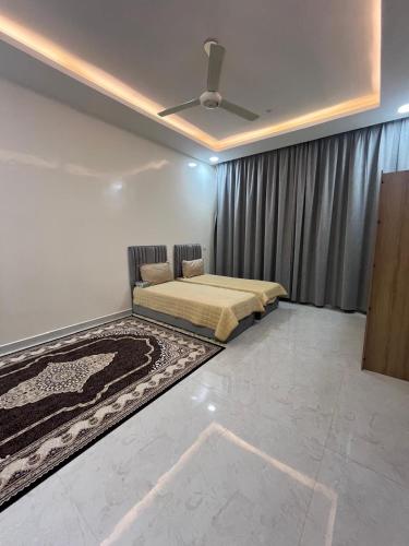 a bedroom with a bed and a ceiling fan at النور ريست هاوس in Ibrā
