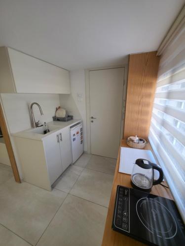a small kitchen with a sink and a stove at studio apartment in Naẕerat ‘Illit
