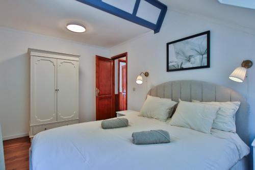 a bedroom with a white bed with two pillows on it at Gite Moments à Soy in Soy