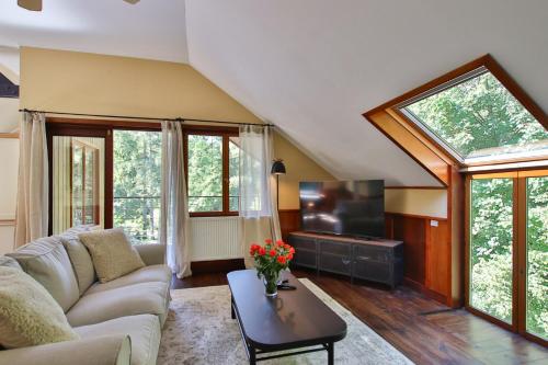a living room with a couch and a tv at Gite Moments à Soy in Soy