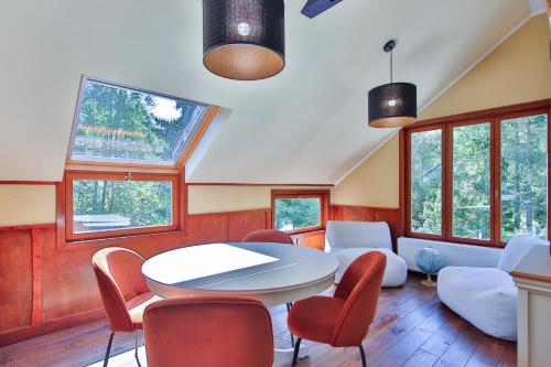 a room with a table and chairs and windows at Gite Moments à Soy in Soy
