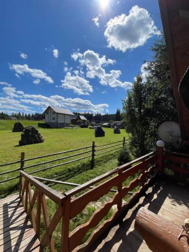 a wooden porch with a fence and a field at Садиба Урочище Луг in Vorokhta