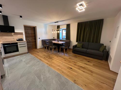 sala de estar amplia con sofá y mesa en Valtnerhof, en San Candido