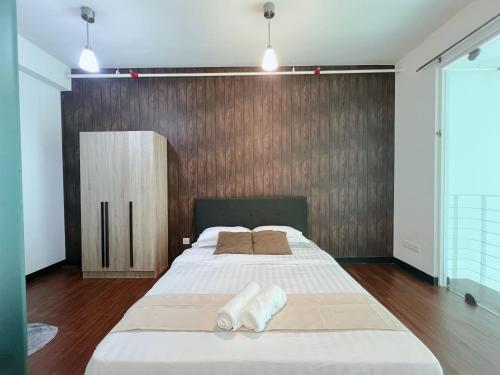 a bedroom with a large bed and a wooden wall at The Nest Living Stay in Gua Sai