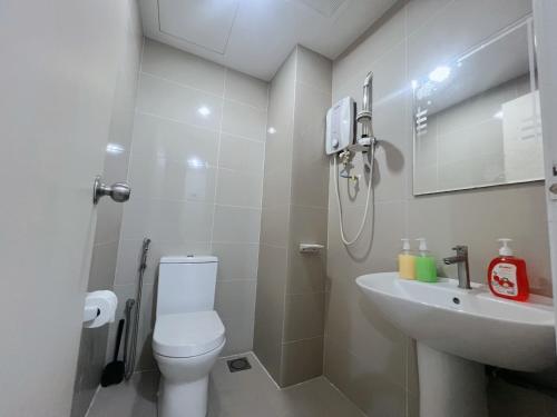 a white bathroom with a toilet and a sink at The Nest Living Stay in Gua Sai