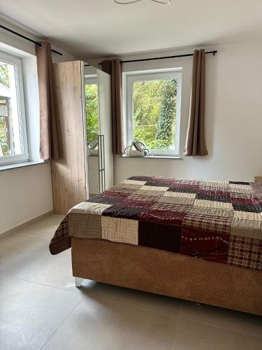 a bedroom with a bed and two windows at Zwei Buchen in BRE