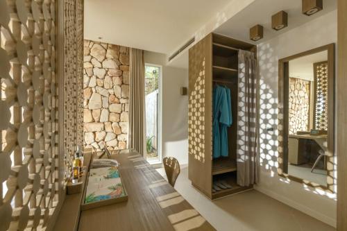 a living room with a stone wall at Mia Resort Nha Trang in Nha Trang