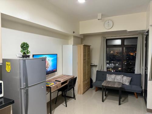 a living room with a refrigerator and a table and a couch at Heart of Cebu Cozy Studio with Pool, Gym, Wifi and Netflix near Cebu City,Ayala and IT Park in Cebu City